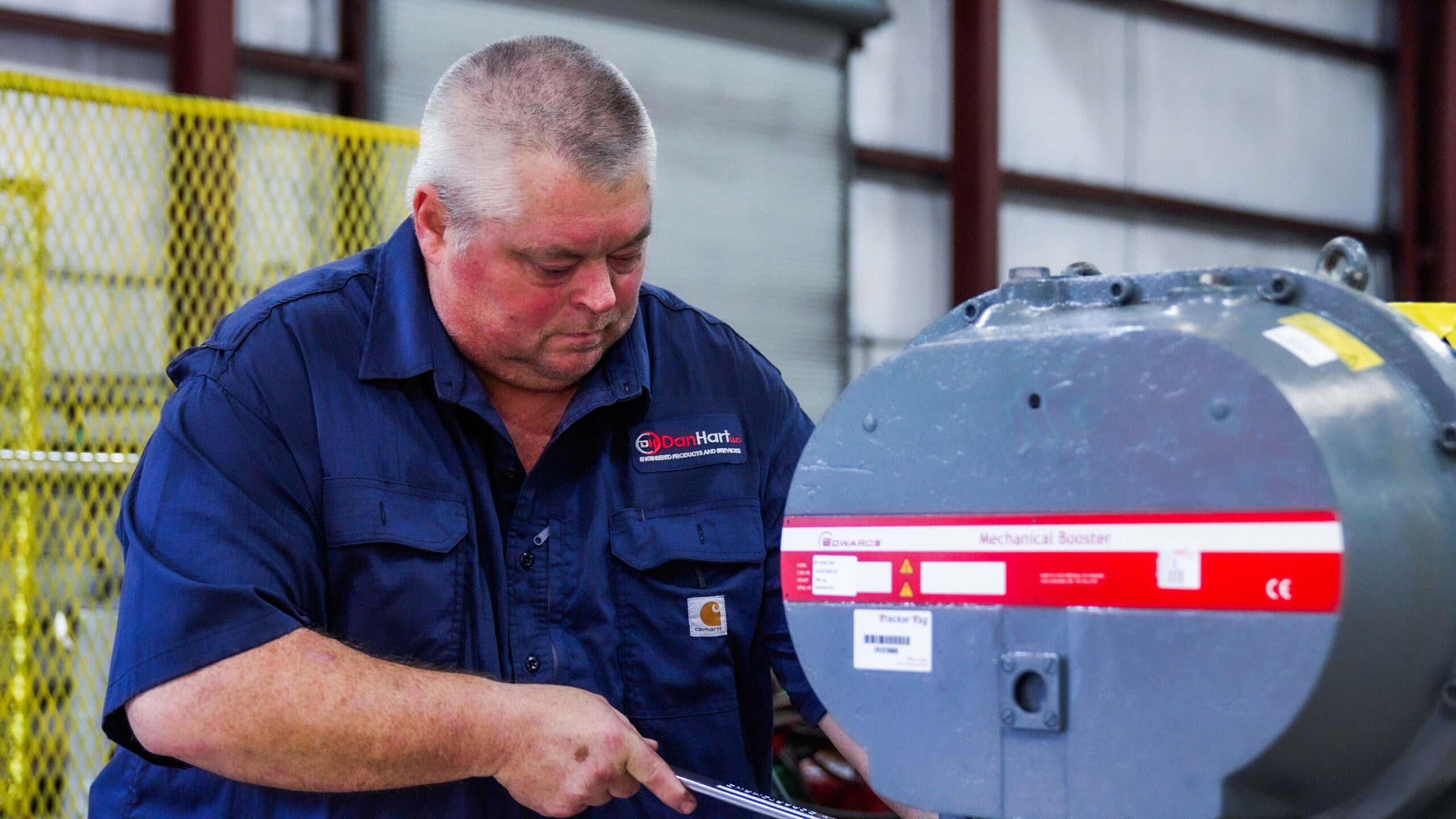 A man working on vacuum pump and blower repair for DanHart, LLC.