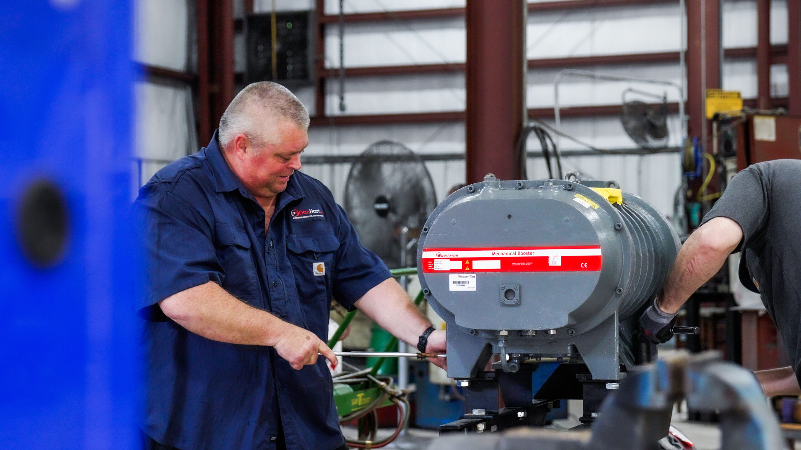 A man working on vacuum pump and blower repair for DanHart, LLC.