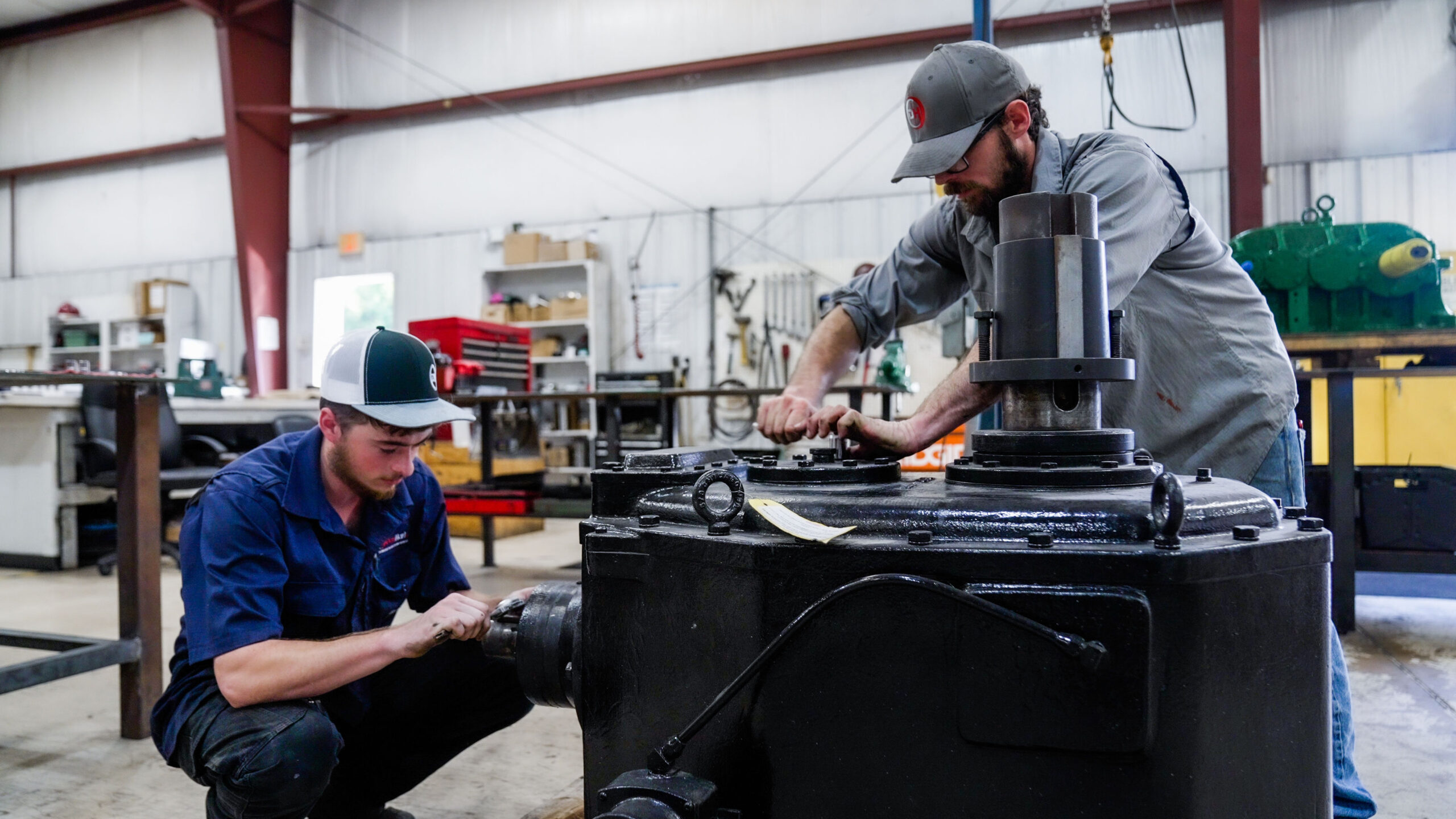 Two men working on vacuum pump and blower repair for DanHart, LLC.